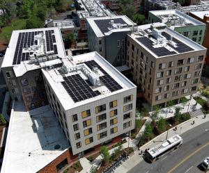 Several large buildings in a city campus photographed from above. You can see several large solar arrays on the roofs of the buildings