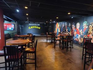 The Cavern performance room at Rockefellas Bar with stage seating and rock-themed wall art.