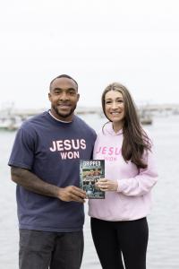TreVeyon Henderson and Stacy Padula stand in front of Plymouth Harbor holding a copy of Gripped Part 6: The Dunkin Legacy