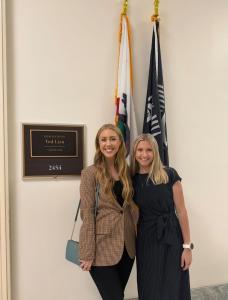 Two women standing in front of the American flag on Capitol Hill