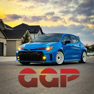 Modified Toyota GR Corolla in Corolla Blue with white wheels and yellow fog lights, photographed at sunset in Cibolo, Texas — Grocery Getter Performance
