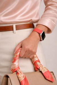 Woman holding bag with twilly, wearing the Liquid in Coral Apple Watch Band by Chalonne