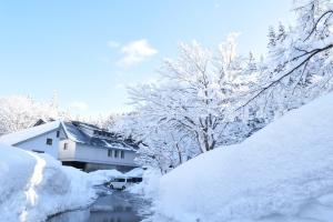 The TSUNAN SAKE BREWERY building surrounded by deep snow in Tsunan, Niigata, Japan, illustrating the heavy snow country terroir behind GO TERRACE.
