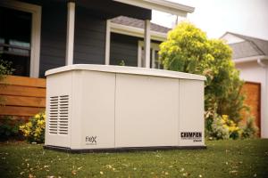 A Champion fleX home standby generator installed near a home in the backyard near landscaping and the back porch.