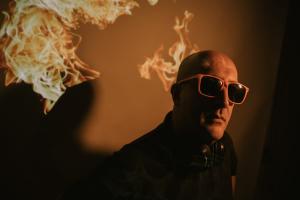 FJ Fatani poses in sunglasses with flames, wearing a black shirt, in photo used for his music career