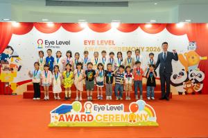 香港得獎學生佩戴獎牌，與嘉賓於 Eye Level 頒獎典禮 2026 舞台上合照。