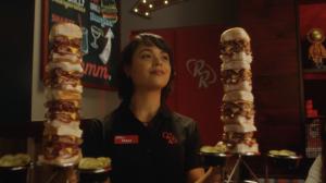 Lorena smiles while holding two towers of sliders