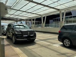 Crni SUV Lincoln Navigator na mjestu preuzimanja u zračnoj luci