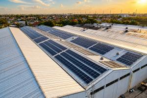 Large industrial rooftop solar installation in the Philippines at sunset, representing solar ownership, energy independence, and long-term savings for commercial operators.