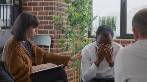 photo of a counseling session with a woman counseling talking with a man client who is experiencing great distress