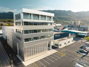 Exterior view of Pavlina headquarters and Super Factory TOSLA 3, showcasing modern architecture and advanced manufacturing facilities