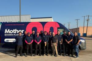 mother modern plumbing staff stands in front of service van at dallas, tx office location