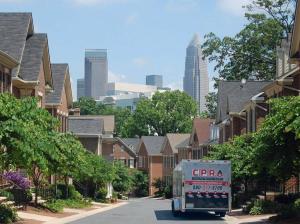 Carolina Pro Restoration trailer in a Charlotte, NC neighborhood with the city skyline in the background
