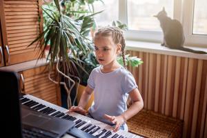 young-musician-playing-classic-digital-piano-at-ho-5G25Q7T