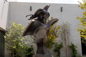 The Richard Hunt Legacy Foundation is proud to celebrate the installation of A bronze sculpture of a bird flying out of a book in a garden setting.