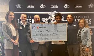 Six people holding a big printout of a check made out to Lawrence High School for $3,000 and held up by Fisher College staff and Lawrence High School student and staff.