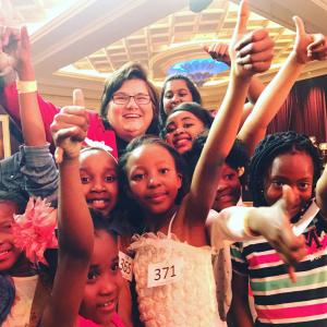 Kim Myers standing with a group of children who just received candy from the states, after auditioning their neighbors in South Africa