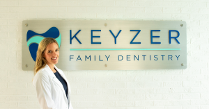 Dr. Noel Keyzer DMD standing in front of Keyzer Family Dentistry sign at the Lakewood Ranch Florida location