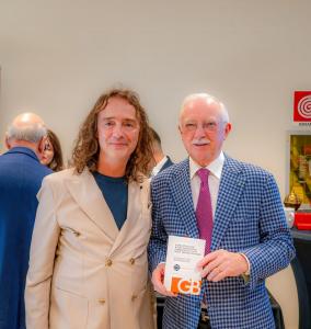 Gianni Buonsante with Ezio Indiani showing the handbook Come affrontare il 2026.