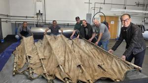 The Margaret's the Couture Cleaner Conservation Team and Chau Thuy, President of the Vietnamese Heritage Museum, presenting the completed, hand-restored historic canvas and bamboo sail from the