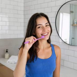 Woman brushing her teeth with a soft-bristle toothbrush.