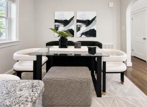 Modern dining room with black dining table, upholstered chairs, abstract artwork, and contemporary styling.