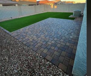 A newly installed artificial turf lawn in a Tucson backyard surrounded by pavers and gravel
