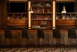Custom-designed full-service bar with a curated food menu at Home2 Suites by Hilton Fort Walton Beach at Freedom Tech Center featuring premium spirits, beer taps, wine, and upscale seating.