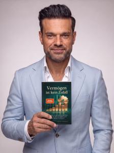 Ferhat Kacmaz hält sein Buch „Vermögen ist kein Zufall“ mit SPIEGEL-Bestseller-Siegel