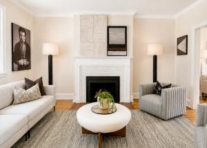 Professionally staged living room in Richmond, Virginia featuring a white fireplace, contemporary seating, designer lighting, modern artwork, and neutral furnishings.