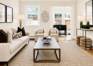 Professionally staged living room in Richmond, Virginia featuring a white fireplace, contemporary seating, designer lighting, modern artwork, and neutral furnishings.