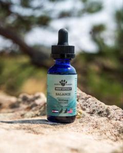 a bottle of hemp extract on a rock outside