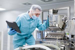 Un technicien en tenue de salle blanche inspecte un équipement de production dans le cadre de travaux de recherche, d'innovation et de développement — le type de dépenses admissibles désormais encadrées par le nouveau Crédit d'impôt pour la recherche, l'i