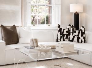 Detail of staged living room by Jsquared Interior Staging and Design in Richmond, VA showing geometric black and white pillows, marble accents, and acrylic coffee table styling