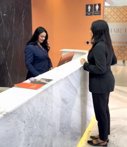 A patient speaks with a Padra staff member at the clinic reception desk.