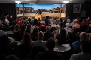 Kellen Cutsforth, Executive Director Western Writers of America, dressed in full western attire speaking about the history of the Western story as America's contribution to literature to a standing room only theatre.