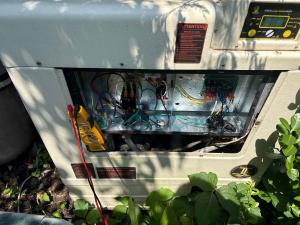 Patchogue Heating and Air Conditioning Outlines Repair or Replace Options for Sayville Pool Heat Pumps at Midseason Technician diagnosing a pool heat pump control board on a Long Island service call