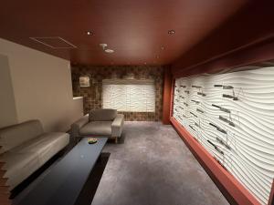 Lounge area inside MUSASHI JAPAN Kyoto store with seating and Japanese kitchen knives displayed on a wave-pattern wall.
