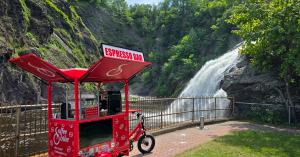 Red Coffee Bike beside Falls in Quebec during THE CROSSING journey across Canada.
