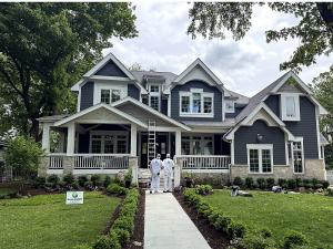 Two Gallagher Paint and Paper painters outside a gray and white home they repainted in Illinois
