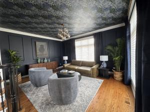 Living room painted navy with white trim and a floral wallpaper ceiling by Gallagher Paint and Paper.