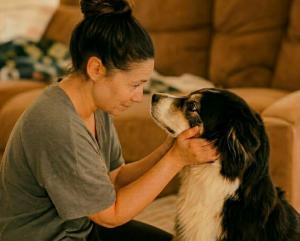 A rescue pet parent looks into the eyes of her adopted dog