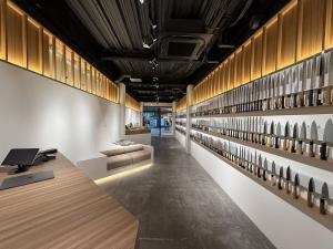 Interior of MUSASHI JAPAN Hiroshima Hondori Store with illuminated knife displays and Japanese kitchen knives along the wall