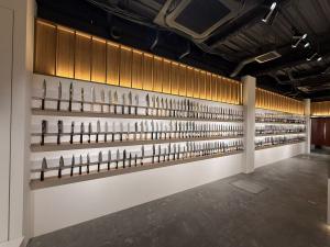 Wall display of Japanese kitchen knives inside MUSASHI JAPAN Hiroshima Hondori Store with warm lighting and wooden fixtures