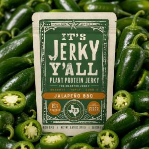 All Y’alls Foods Jalapeño BBQ plant protein jerky bag surrounded by fresh jalapeños, featuring The Smarter Jerky™ packaging, 15g protein, and 8g fiber.