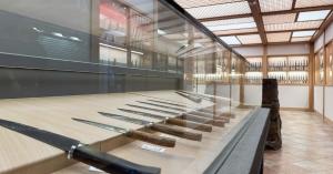 Close-up view of Japanese kitchen knives displayed in a glass case at MUSASHI JAPAN Osaka Namba Ebisubashi Store