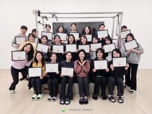 MagicBody graduates holding certificates in a group photo
