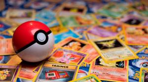 A red and white Pokéball resting on a pile of vintage Pokémon trading cards