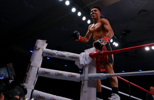 Daniel Chucky Barrera standing on the boxing ring ropes after a victory