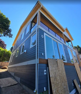 Multi-story residential building undergoing structural renovation and siding installation by Final Touch Construction LLC.